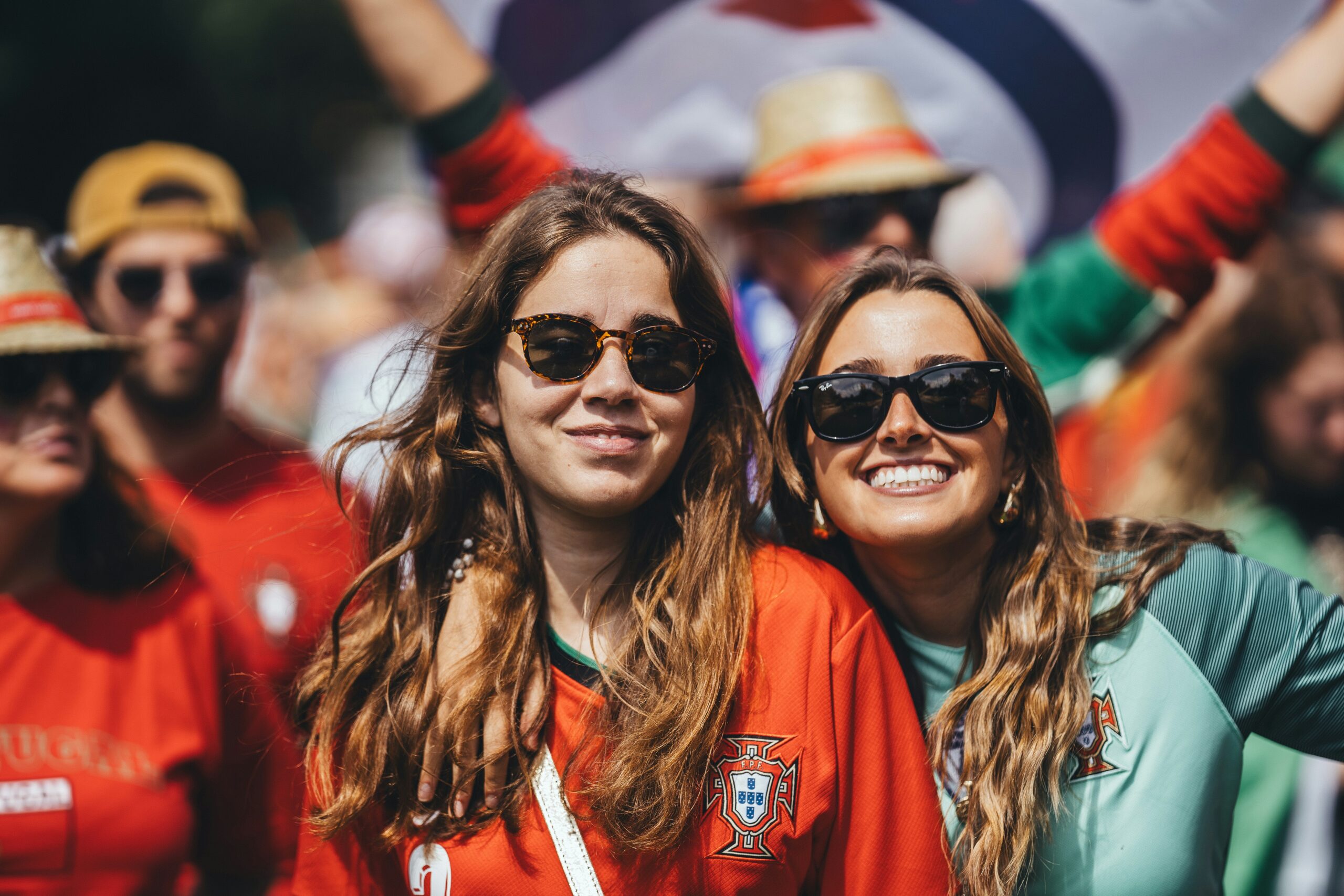 Due tifose sorridenti tra il pubblico di un evento sportivo
